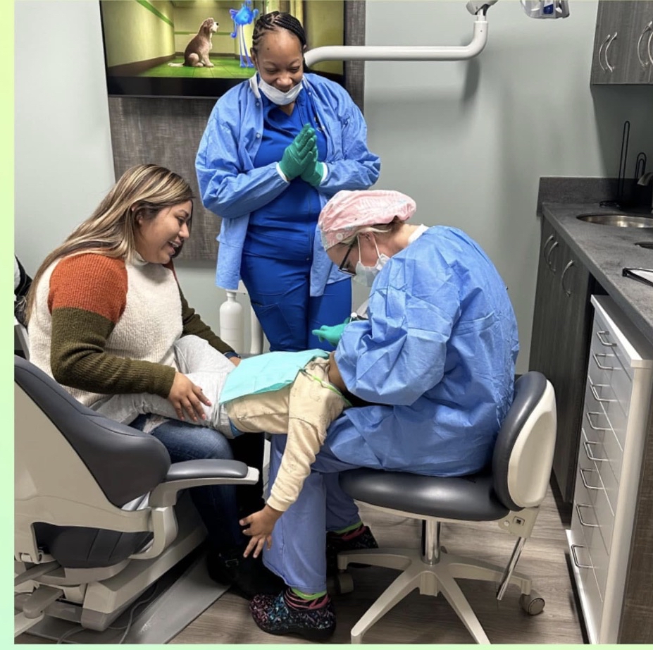 Child receiving dental care with a parent close by